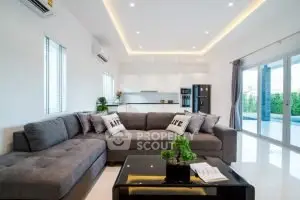 Spacious modern living room with large sectional sofa and open kitchen layout.