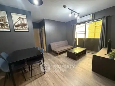 Modern living room with stylish decor, featuring a cozy sofa, dining table, and large window for natural light.
