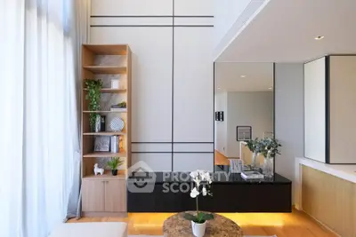 Modern living room with stylish decor and natural light, featuring a sleek bookshelf and elegant furnishings.