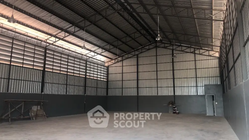 Spacious industrial warehouse with high ceilings and ample natural light.
