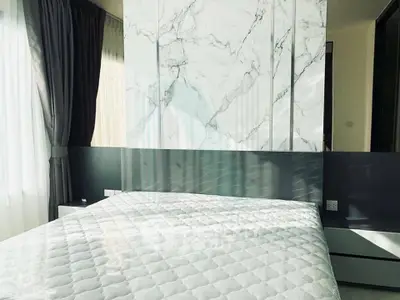 Modern bedroom with marble accent wall and elegant curtains