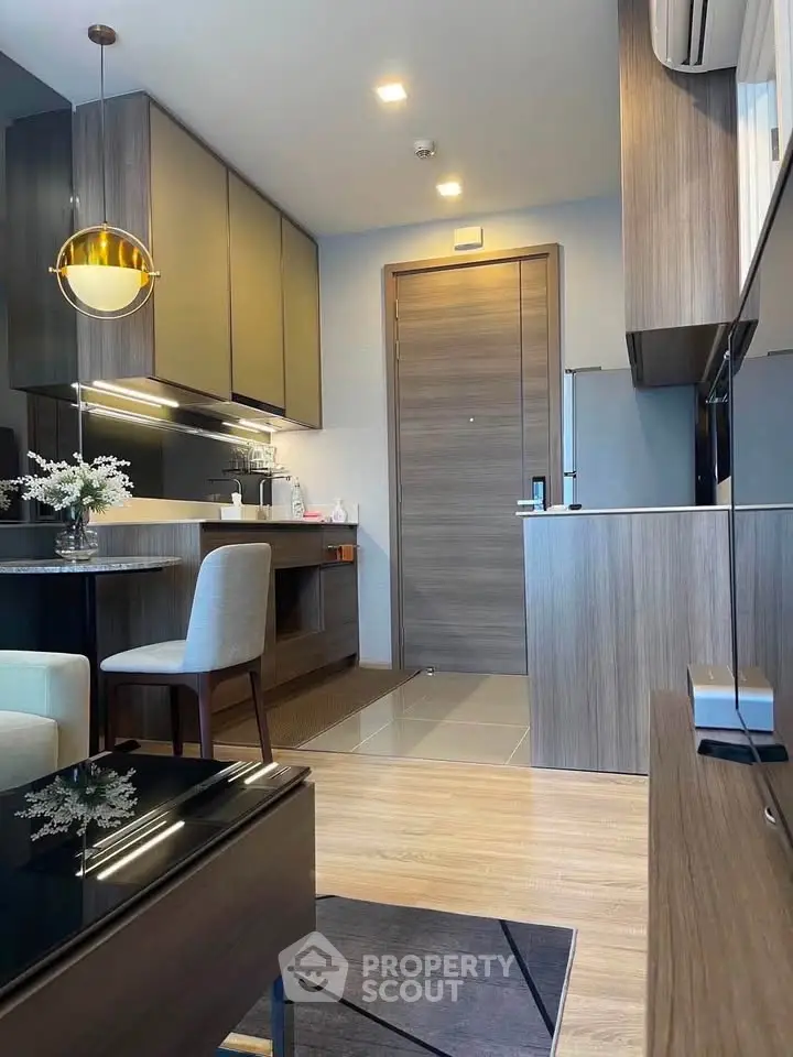 Modern kitchen with sleek cabinetry and dining area in stylish apartment