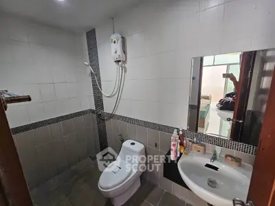 Modern bathroom with sleek fixtures and wall-mounted water heater, ideal for compact living spaces.