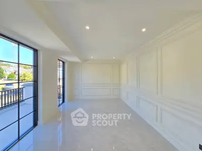 Spacious empty room with elegant molding and large windows