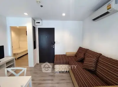 Modern living room with striped sofa and air conditioning in a cozy apartment