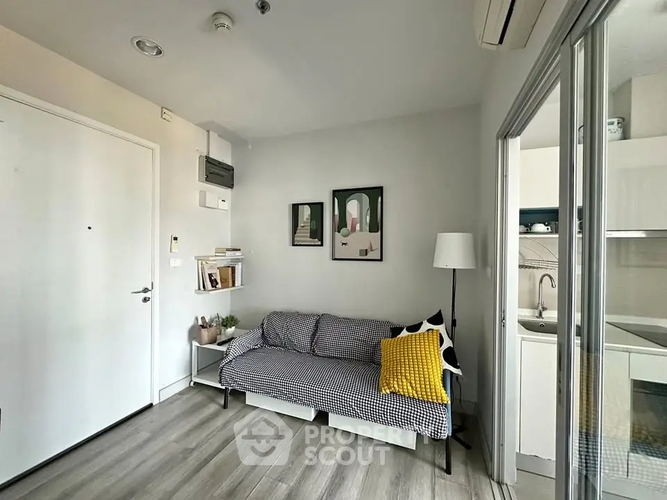 Cozy living room with modern decor and adjacent kitchen in a stylish apartment.