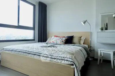 Modern bedroom with large window and stylish decor in urban apartment