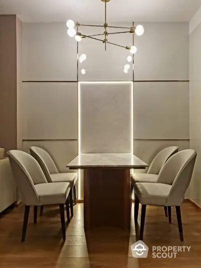 Elegant dining area with modern chandelier and stylish chairs around a sleek table.