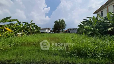 Spacious green land plot with lush vegetation and clear sky, ideal for development.