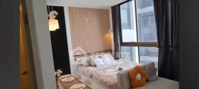 Modern bedroom with large windows and stylish decor in a high-rise apartment.