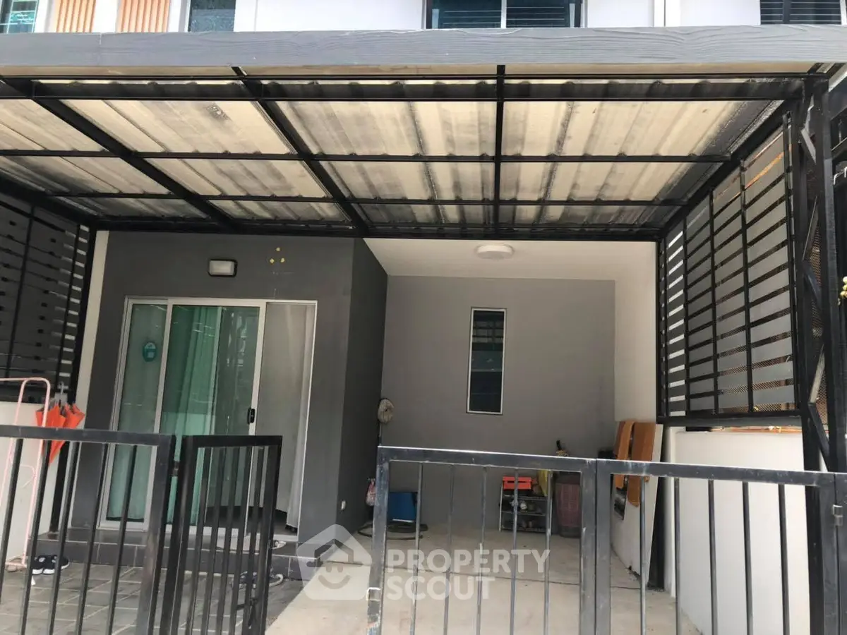 Modern townhouse entrance with covered parking and sleek design