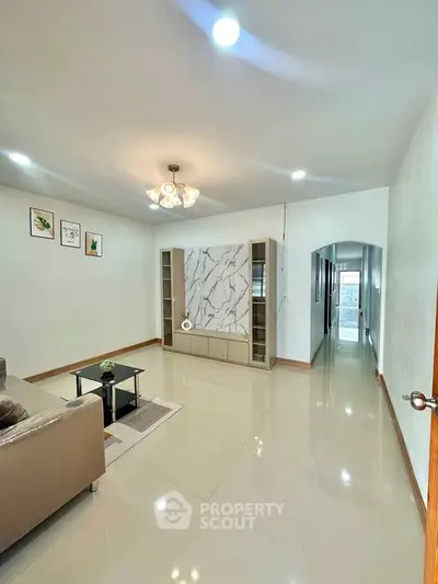 Spacious living room with modern decor and elegant lighting in a stylish home.