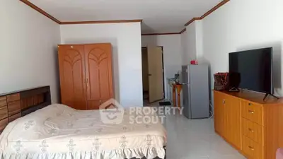 Spacious bedroom with modern furnishings and kitchenette in a cozy apartment.