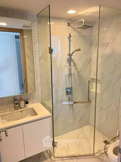 Modern bathroom with glass shower enclosure and sleek vanity