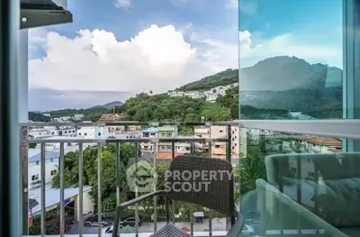 Stunning balcony view overlooking lush green hills and cityscape, perfect for relaxation and enjoying nature.