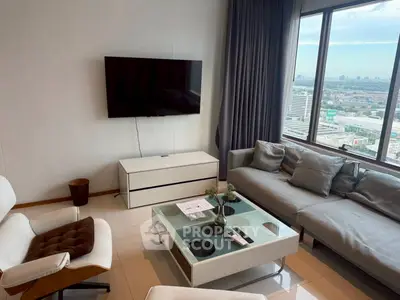 Modern living room with city view, sleek furniture, and large windows for natural light.