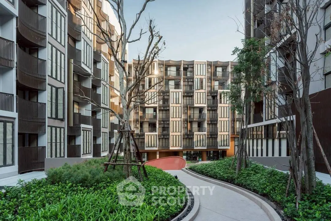 Modern apartment building with lush garden and unique architectural design.