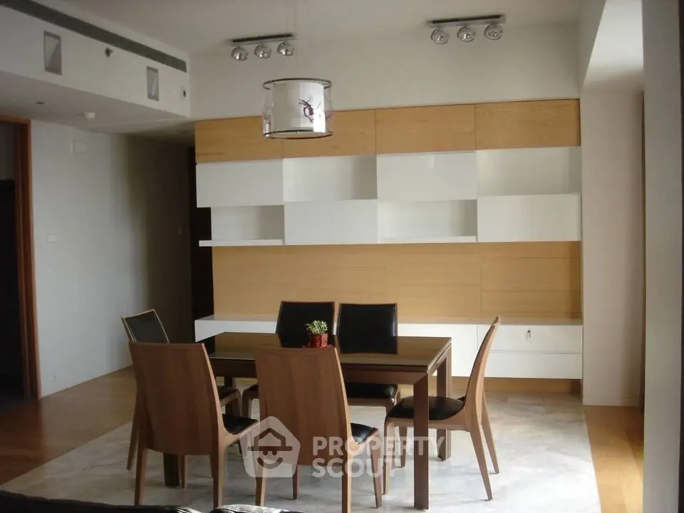 Modern dining room with sleek wooden furniture and stylish lighting in a contemporary apartment.