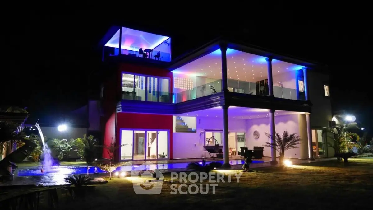 Stunning modern villa with illuminated pool and spacious balcony at night