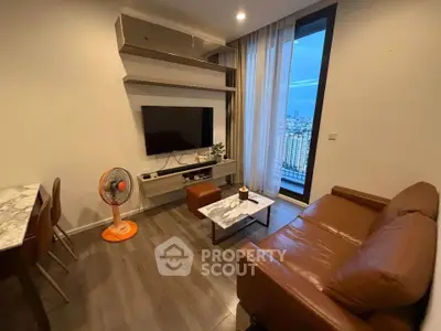 Modern living room with city view, featuring a leather sofa and wall-mounted TV.