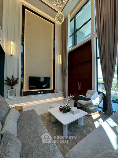 Luxurious high-ceiling living room with elegant decor and large windows for natural light.