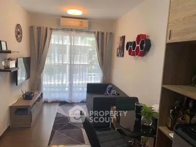 Modern living room with stylish decor, cozy seating, and natural light from large windows.