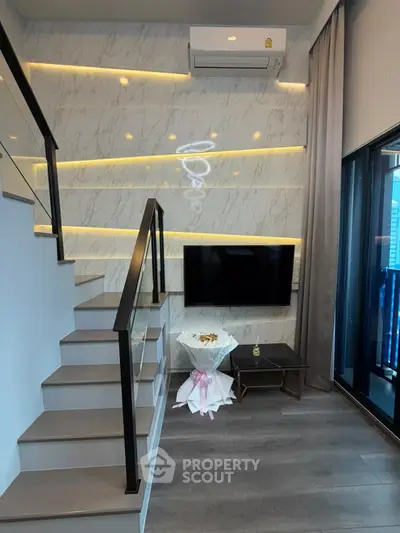 Modern living room with stylish staircase and wall-mounted TV in a chic apartment