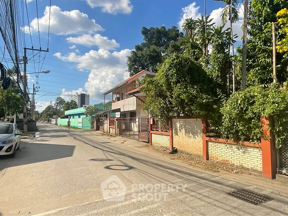 Charming suburban street view with lush greenery and clear blue sky, ideal for peaceful living.