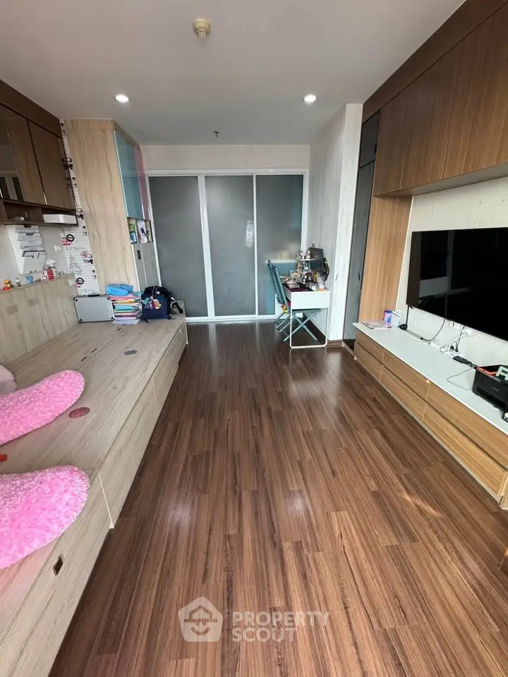 Spacious living room with wooden flooring and modern decor, perfect for family gatherings.