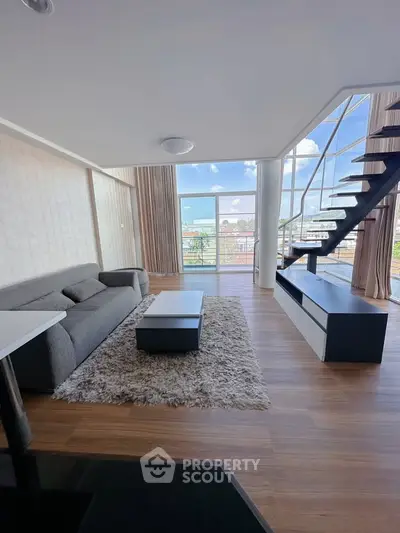 Modern living room with stylish staircase and panoramic windows
