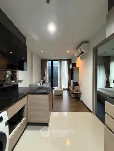 Modern open-layout kitchen and living room with sleek design and natural light