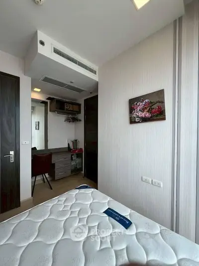 Modern bedroom with cozy mattress and study area, perfect for comfort and productivity.