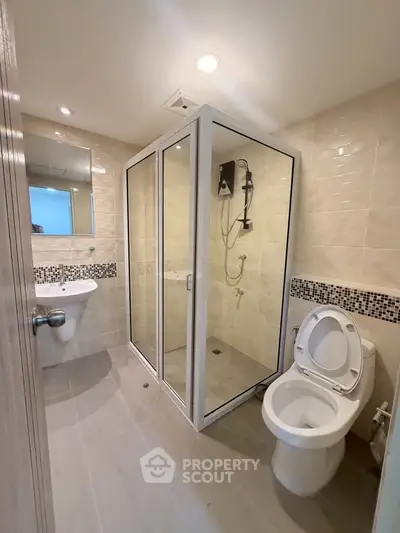 Modern bathroom with glass shower enclosure and sleek fixtures