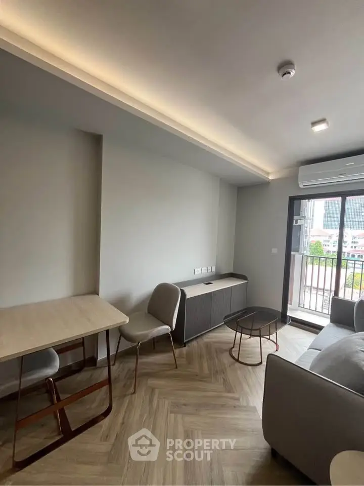 Modern living room with balcony access and stylish furniture in urban apartment.
