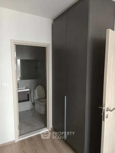 Modern bathroom with sleek design and adjacent wardrobe in a contemporary apartment.