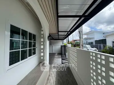 Charming modern balcony with stylish railing and covered roof, perfect for relaxation.