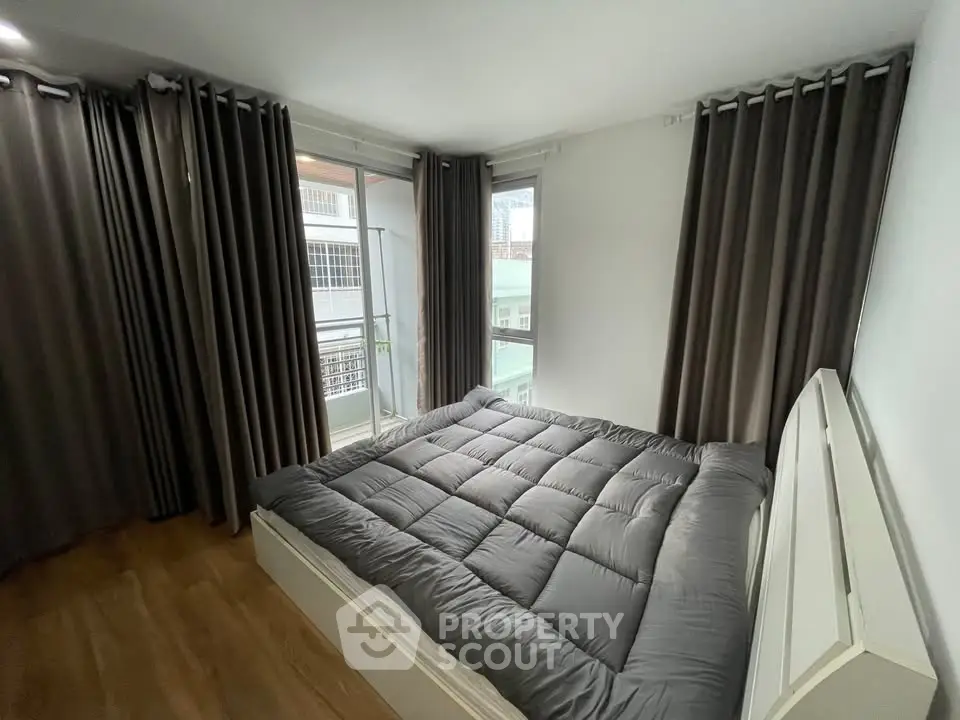 Cozy bedroom with modern decor and large windows offering natural light