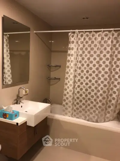 Modern bathroom with stylish vanity and polka dot shower curtain