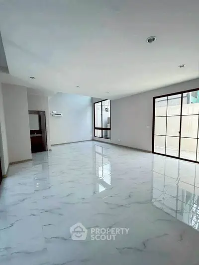 Spacious modern living room with marble flooring and large windows