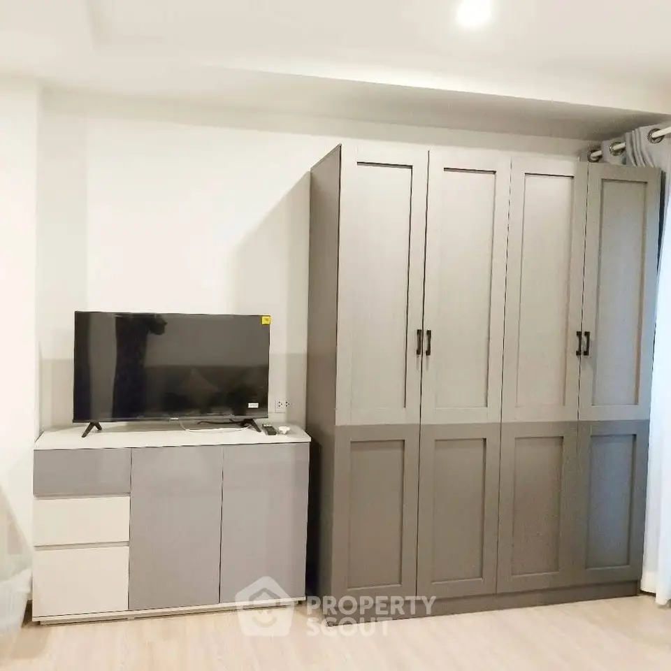 Modern living room with sleek TV stand and spacious wardrobe, perfect for stylish urban living.