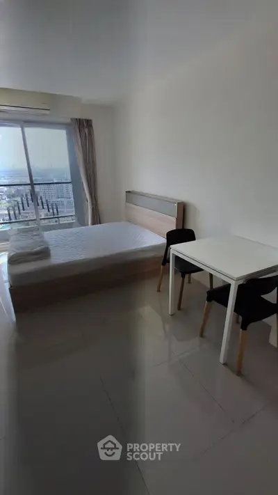Modern minimalist bedroom with balcony view in high-rise apartment