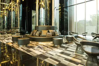 Luxurious modern lobby with stylish seating and floor-to-ceiling windows in a high-end building.