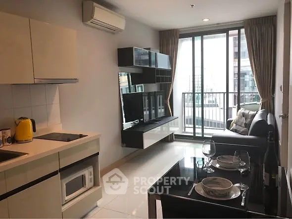 Modern living room with open kitchen and balcony view in urban apartment