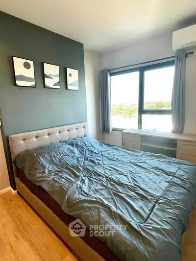 Cozy bedroom with modern decor and large window offering natural light