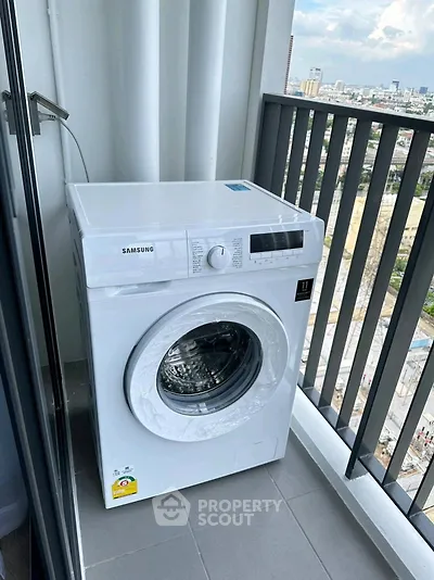 Modern washing machine on a high-rise balcony with city view, perfect for urban living convenience.