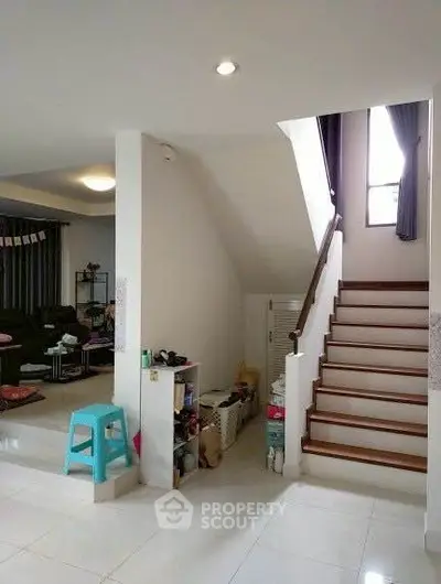 Modern interior with staircase and cozy living area, bright and inviting space.