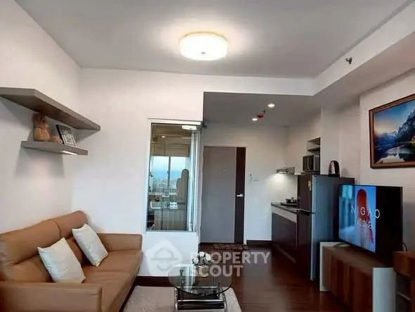 Modern living room with cozy sofa and sleek kitchen in open layout apartment.