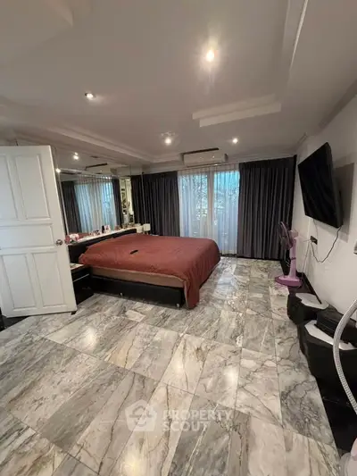Luxurious bedroom with marble flooring and elegant decor, featuring a large bed and modern amenities.