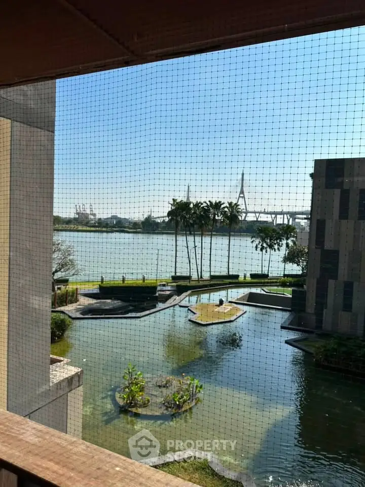 Stunning river view from a modern building with lush landscaping and serene water features.