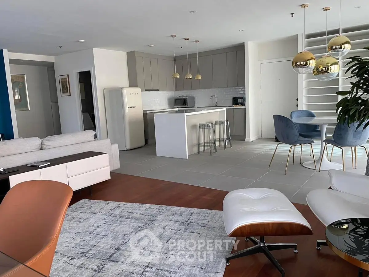 Modern open-plan living room and kitchen with stylish furniture and sleek design.